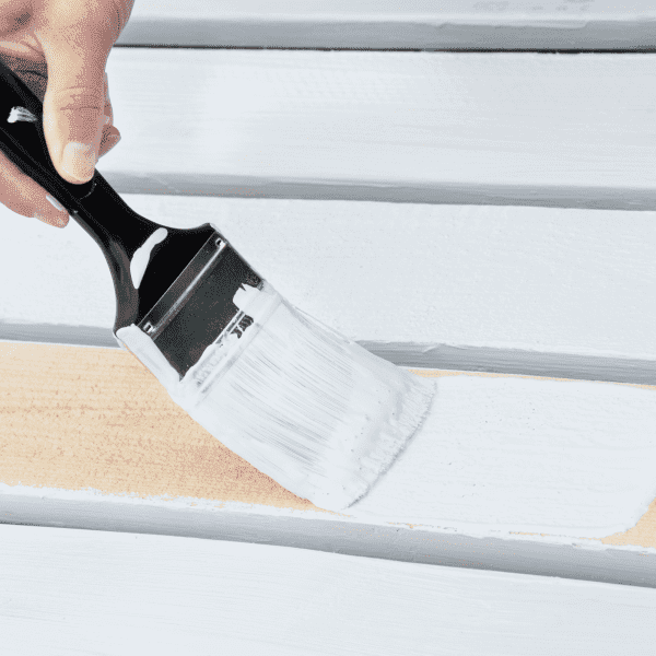 Paintbrush applying white paint